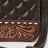 Quilted brown leather crossbody bag with hand-tooled floral leather accent, braided top handles, and adjustable shoulder strap
