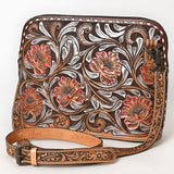 Tooled leather crossbody bag with pink floral carvings, silver scroll accents, and matching tooled leather strap

